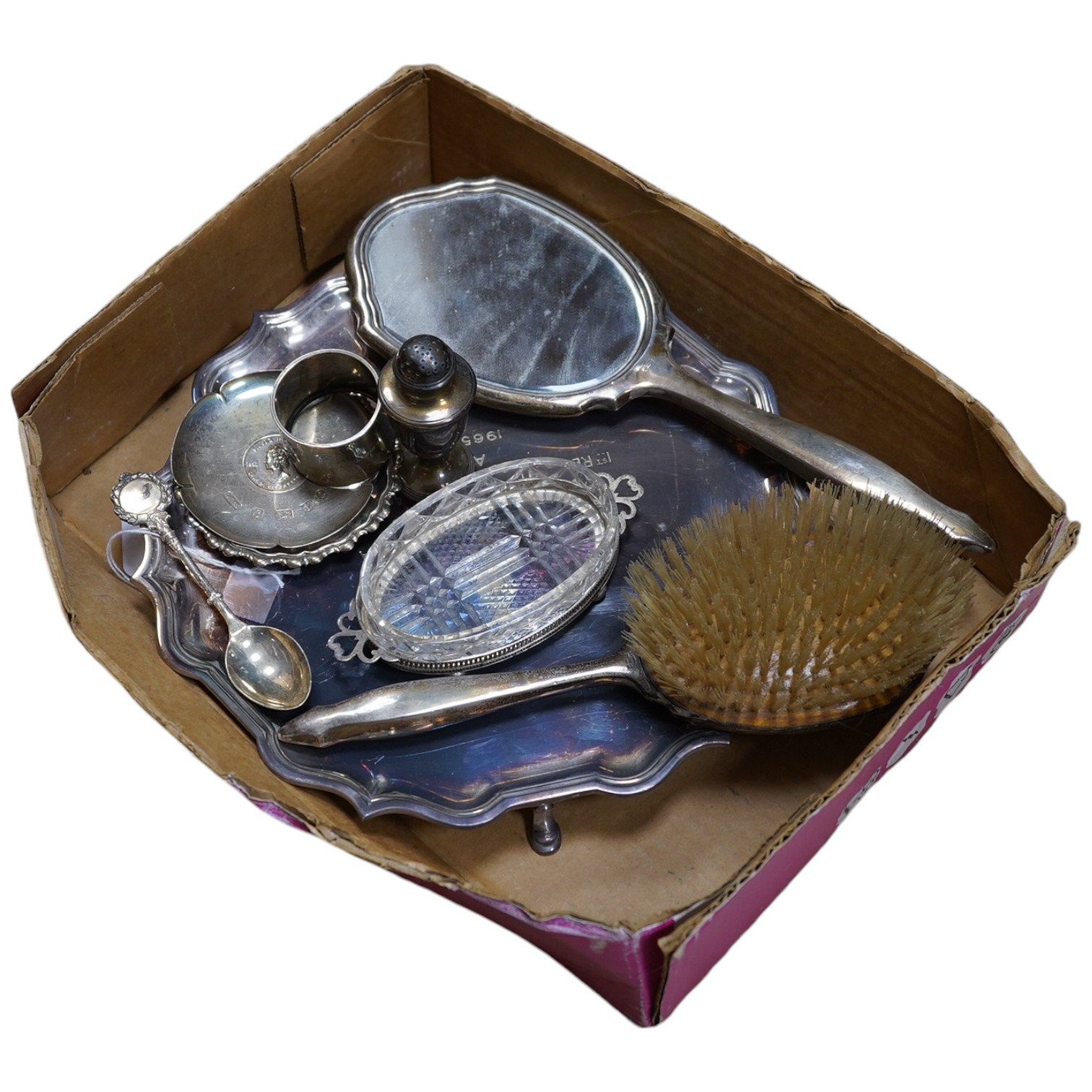 Sundry silver including a silver salver by Garrard & Co, London, 1964, two small dishes, napkin ring, pepperette, a mounted glass butter dish, spoon and a mounted hand mirror and brush, 23.3oz. Condition - poor to fair